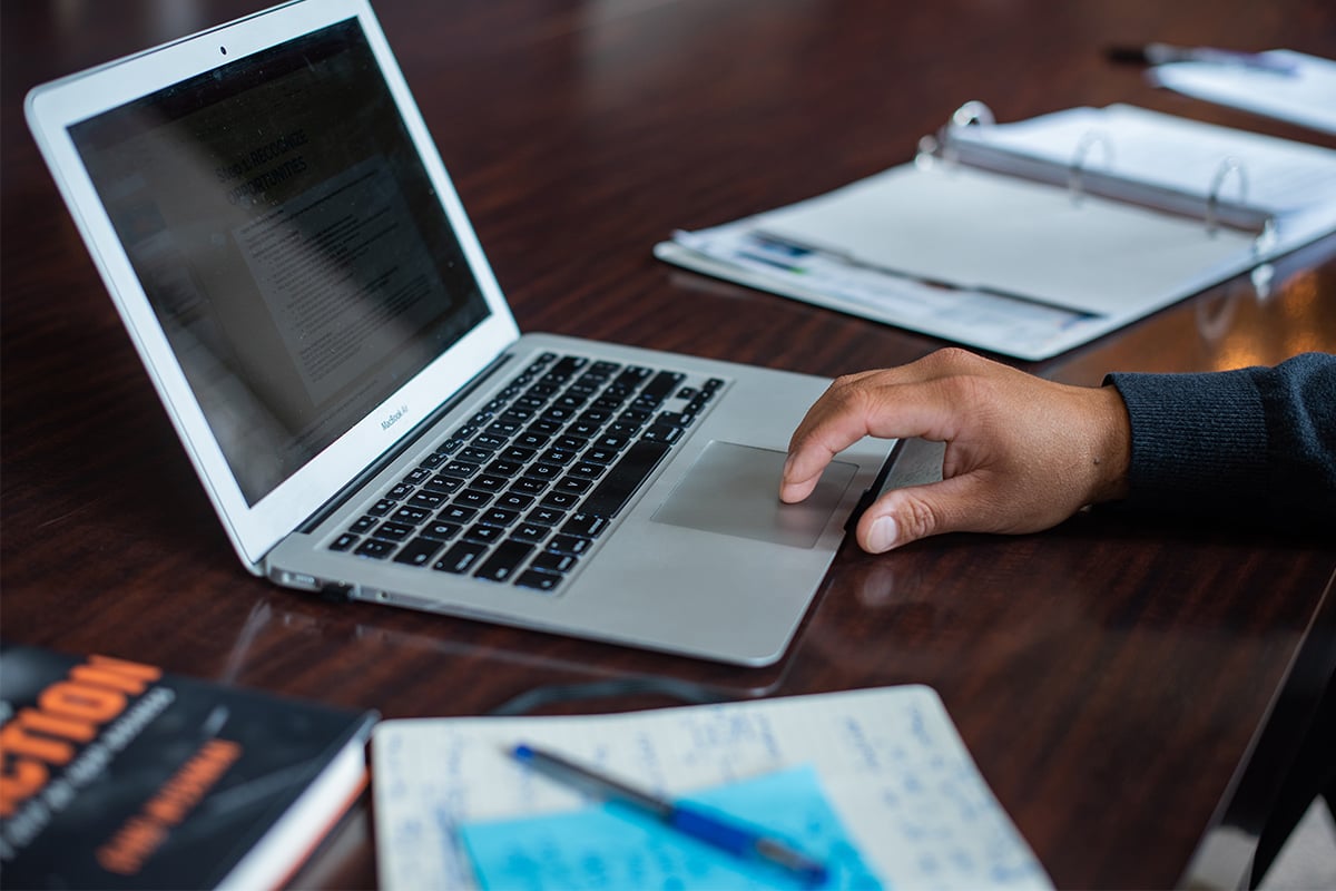 Hand-using-laptop-and-notes