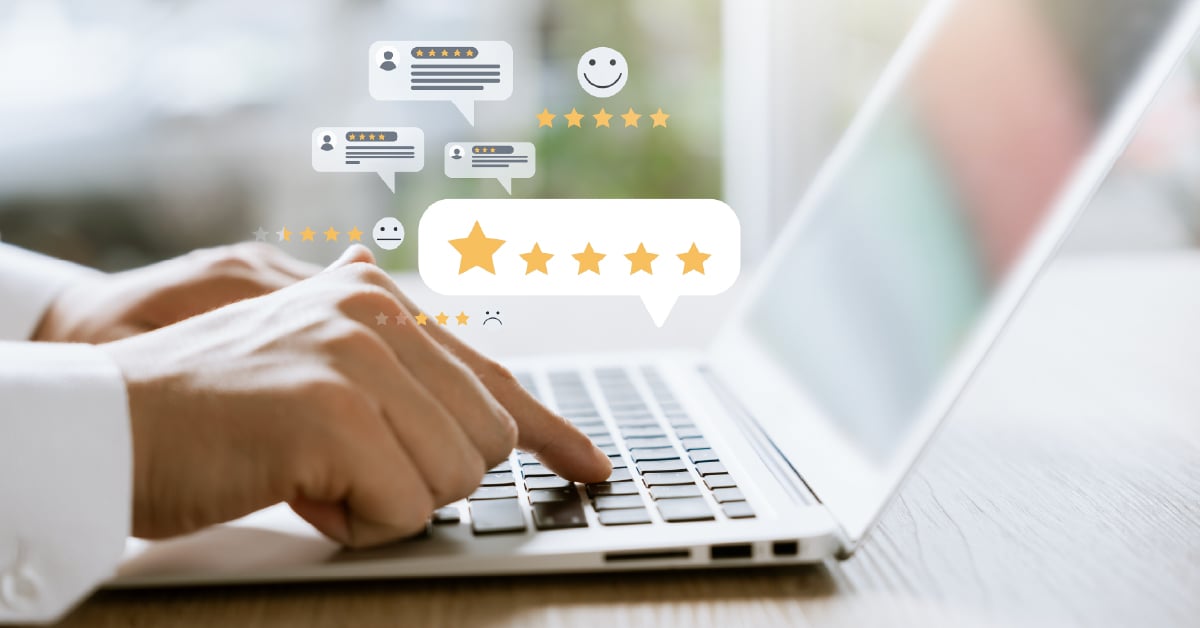 Close-up of a hand typing on a laptop keyboard with graphic overlays of star ratings and chat/review icons